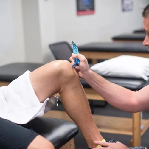 Physical therapist works with patients knee