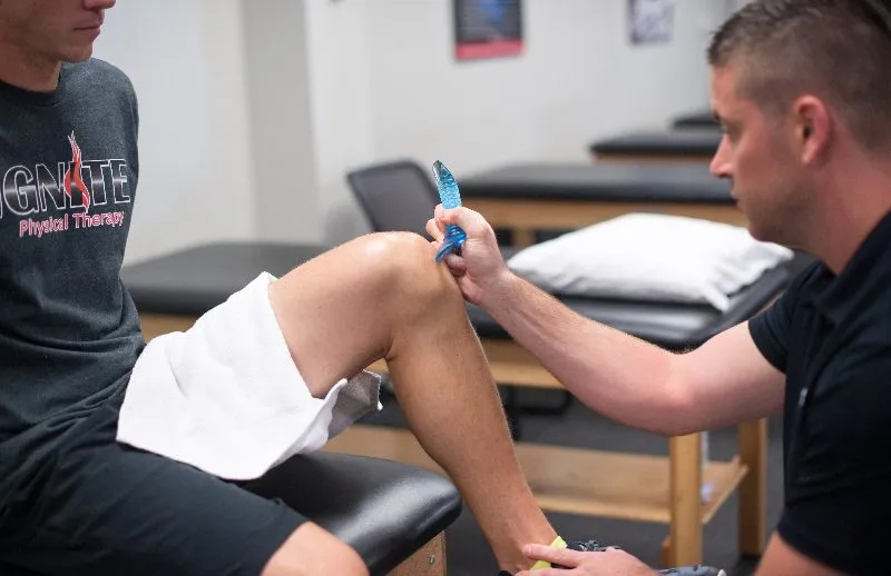 Physical therapist works with patients knee